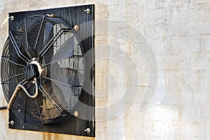 Big industrial fan in a white brick wall of a factory. Ventilation of factory building outdoors