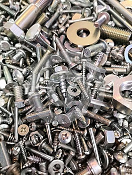 A big and interesting pile of new and shiny metal nuts and bolts, screws and washers.