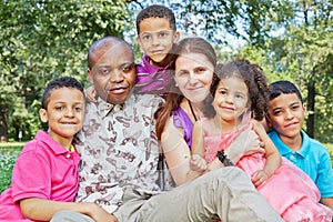 Big interracial family of six sits tight embraced