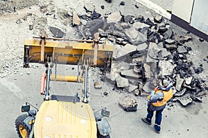 Big jackhammer drill drilling road.Heavy machinery crushing asphalt for stormwater drain repair