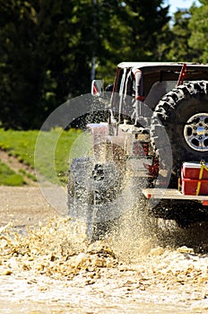 Big Jeep splashing mud in the mountains