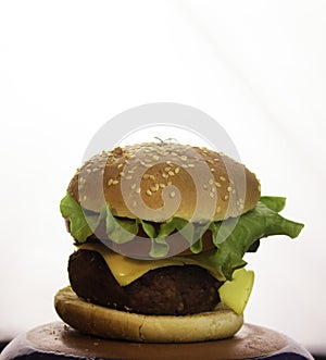 Big juicy burger with beef cutlet, fresh vegetables and melted cheese. Fast food, high-calorie food