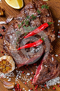 big juicy grilled Ribeye steak on a wooden board rare