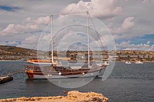 A big ketch type sailboat moored in the harbor of Ghadira, Malta. Visible both masts, front bigger main mast and the rear smaller photo