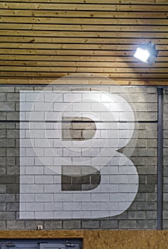 Big letter painted on brick hall wall for devide room for sections