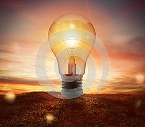Big lightbulb in a field during the sunset ads concept of idea