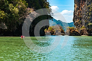 Big limestone rocks and tourists canoeing in Phang nga bay, Thai