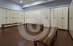 Big lockers with a wood bench in a locker room with doors closed