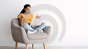 Big Luck. Emotional Joyful Young Woman Sitting In Armchair With Laptop