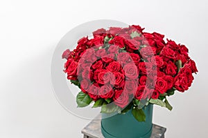 Big luxury bright bouquet on wooden table. One hundred of garden red roses. Color passionately scarlet, Autumn mood