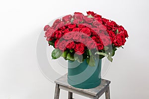 Big luxury bright bouquet on wooden table. One hundred of garden red roses. Color passionately scarlet, Autumn mood