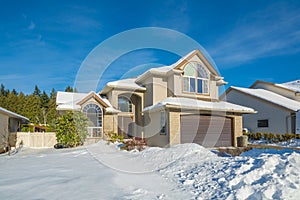 Big luxury house with front yard in snow. Residential house on winter day