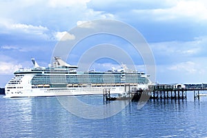 Big luxury passenger liner leaving a port