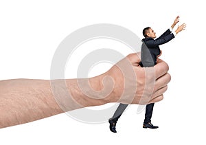Big male hand holding businessman reaching out isolated on white background