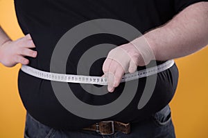 The big man makes measurements with the tape of his fat stomach.