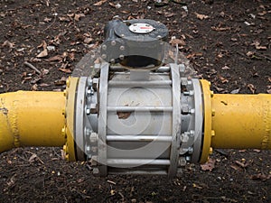 Close up shot big valve on a thick yellow gas oil water pipeline tube