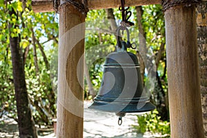 Big metal bell near restaurant entrance at tropical island