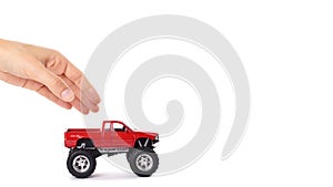 big metal red toy car offroad with monster wheels in hand isolated on white background. copy space, template