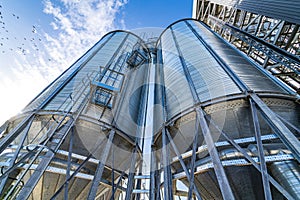 Big metallic container on blue sky. Fuel tank in big factory. Large towers at navy sky.