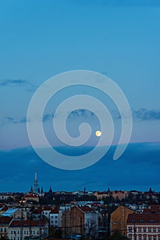 Big moon over the town with blue sky and clouds