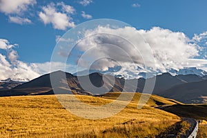 Big mountain Elbrus against the blue sky. View from a large plateau and steep cliffs.