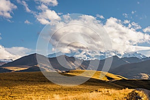 Big mountain Elbrus against the blue sky. View from a large plateau and steep cliffs.