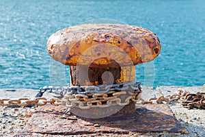 big oarange old rusty mooring bitt on a dock