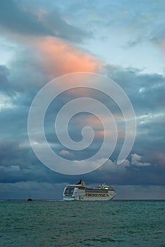 Big oceanic ship sailing off from Yalta port at fall evening