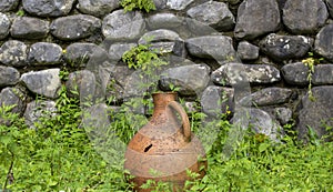 Big old clay jug. Old ancient clay vase outdoors. Still life of ceramic pots. Selective focus. Old clay jugs in the brick and