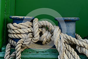 A big old cleat with classic mooring rope tied on it