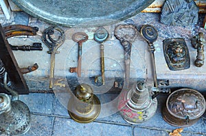 Big old keys, horseshoes and metal dishes on the counter of an antique shop