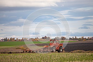 big old model tractor plows the ground