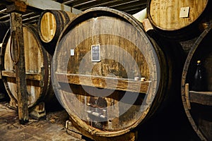 Big old oak casks of pommeau of calvados in a cellar