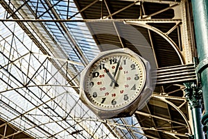 Big old, vintage clock hang with roof of Train station