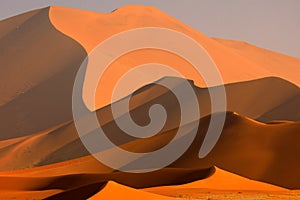 Big orange dune with blue sky and clouds, Sossusvlei, Namib desert, Namibia, Southern Africa. Red sand, biggest dun in the world. photo
