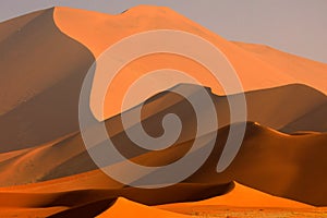 Big orange dune with blue sky and clouds, Sossusvlei, Namib desert, Namibia, Southern Africa. Red sand, biggest dun in the world.