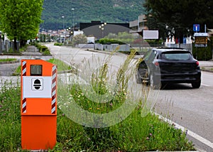 Big orange Safety Speed Camera and a black car on the road