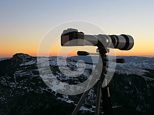 big photo camera with zoom lens in nature