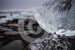 big piece of ice on a black beach