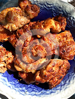 Big piece of slow cooked oven-barbecued pulled pork shoulder on chopping board on plate, view from above, close-up