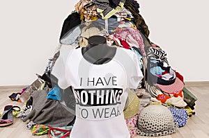 Big pile of clothes thrown on the ground with a t-shirt saying nothing to wear.