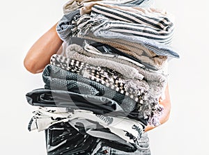 Big pile grey and beige laundry in woman hands close up image on white background