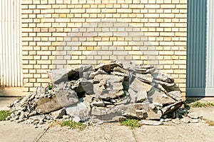 Big pile of old asphalt road debris parts and stones damaged and aged on the sidewalk