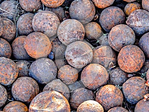 Big pile of an old rusty cannonballs