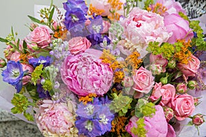 Big pink purple bouquet by florist with different flowers and roses close-up