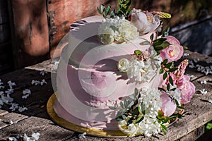 Big pink wedding cake decorated by flowers