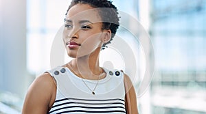 Big plans in that beautiful mind. an attractive young businesswoman looking thoughtful while standing in a modern office