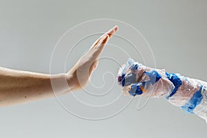 Big plastic hand made of garbage with another one  on white studio background
