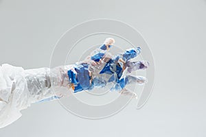 Big plastic hand made of garbage  on white studio background