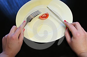 Big plate with a little piece of food and woman hands